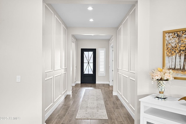 foyer entrance featuring baseboards, wood finished floors, and recessed lighting