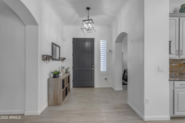 foyer featuring a notable chandelier, crown molding, and light hardwood / wood-style flooring