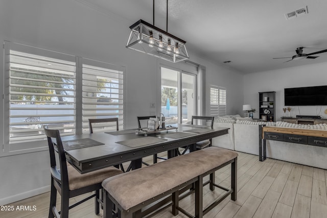 dining area featuring crown molding, ceiling fan, and light hardwood / wood-style flooring