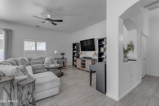 living room with ornamental molding, light hardwood / wood-style floors, and ceiling fan