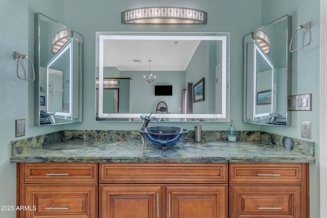 bathroom with vanity and a notable chandelier