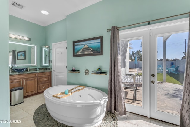 bathroom featuring tile patterned flooring, vanity, french doors, and a bathing tub