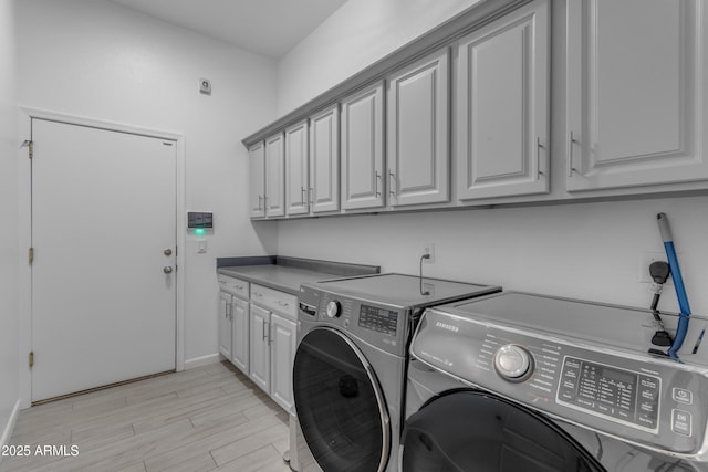 washroom featuring cabinets, light hardwood / wood-style floors, and independent washer and dryer