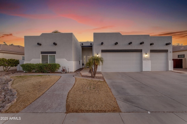 pueblo revival-style home with a garage