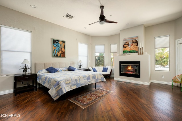 bedroom featuring multiple windows, dark wood-type flooring, and ceiling fan