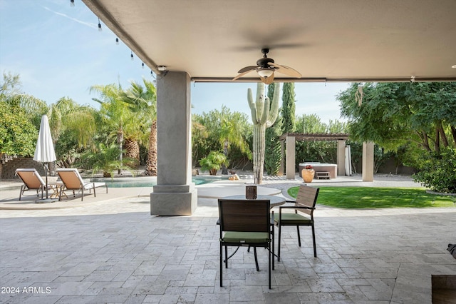 view of patio / terrace with ceiling fan and a swimming pool with hot tub