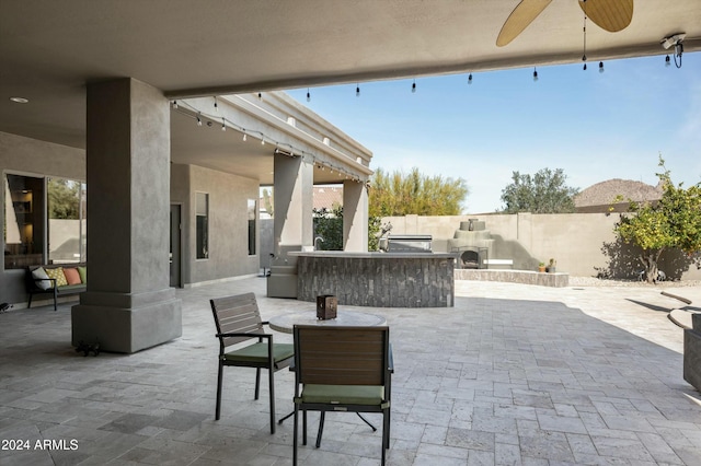 view of patio / terrace with exterior bar, area for grilling, and ceiling fan