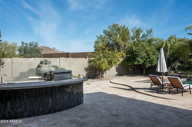 view of patio with area for grilling and sink