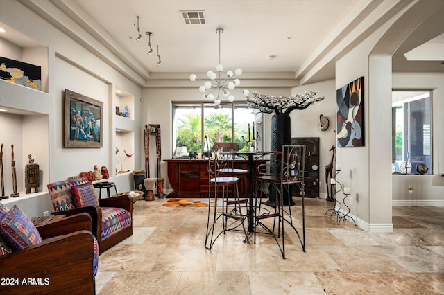 dining space with a tray ceiling and a chandelier