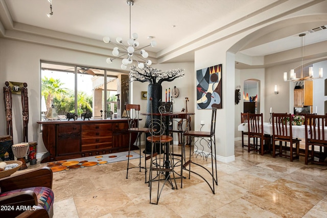 dining space featuring a raised ceiling and an inviting chandelier