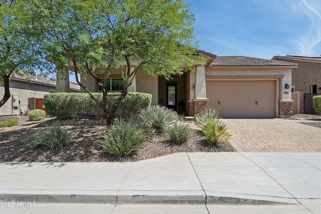 11872 W Duane Ln, Peoria, AZ 85383 - view of front of home featuring an attached garage, decorative driveway, stucco siding, and stone siding