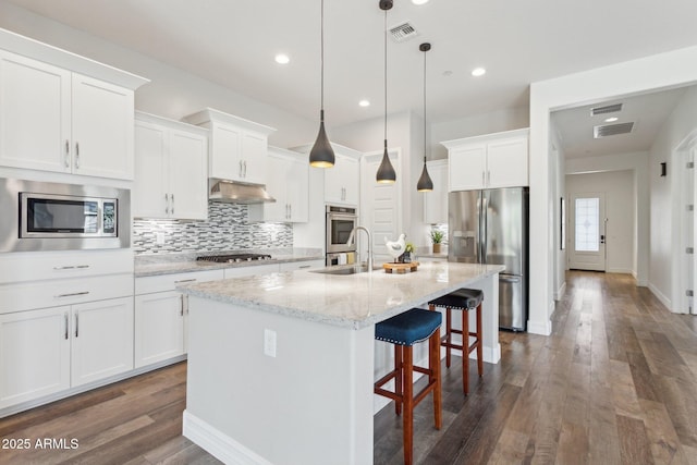 11872 W Duane Ln, Peoria, AZ 85383 - kitchen featuring appliances with stainless steel finishes, under cabinet range hood, a sink, dark wood finished floors, and tasteful backsplash