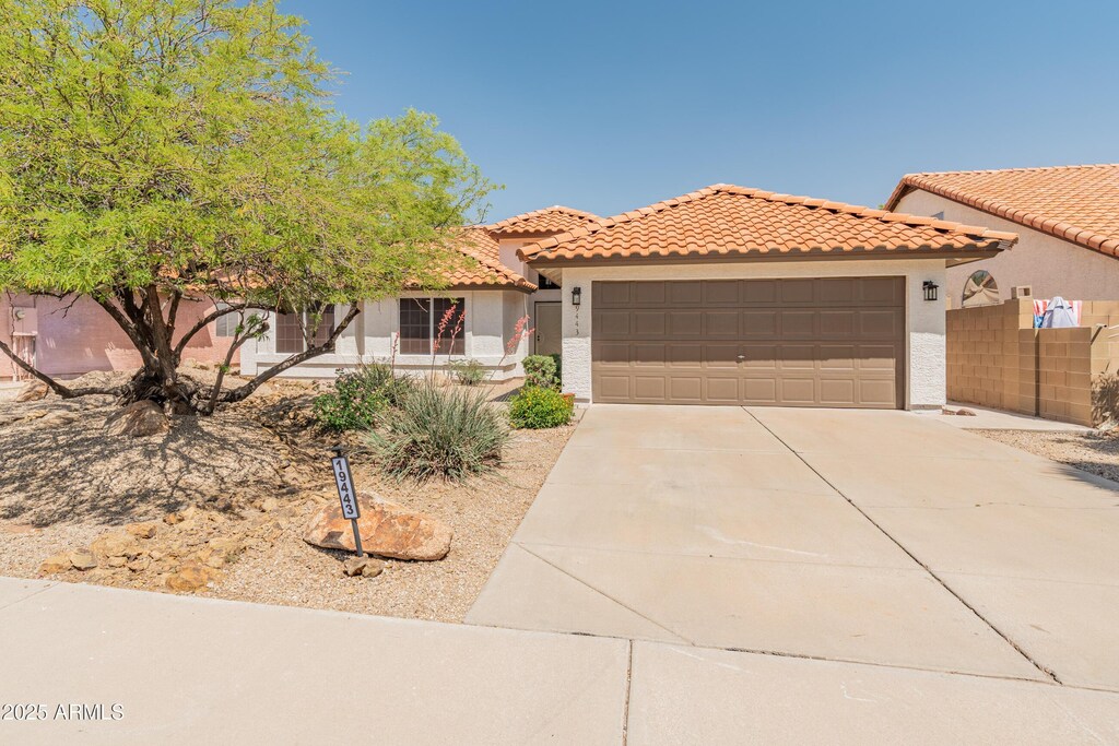 19443 N 36th St, Phoenix, AZ 85050 - mediterranean / spanish home featuring an attached garage, stucco siding, a tiled roof, and concrete driveway
