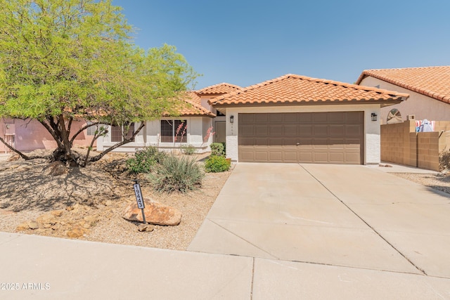 mediterranean / spanish home featuring an attached garage, stucco siding, a tiled roof, and concrete driveway