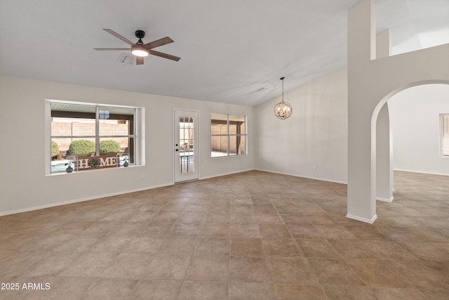 unfurnished living room featuring arched walkways, ceiling fan with notable chandelier, a healthy amount of sunlight, and high vaulted ceiling