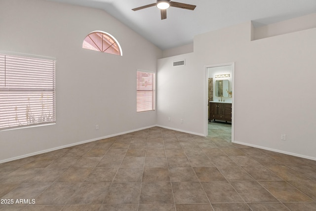 spare room featuring ceiling fan, visible vents, baseboards, and high vaulted ceiling