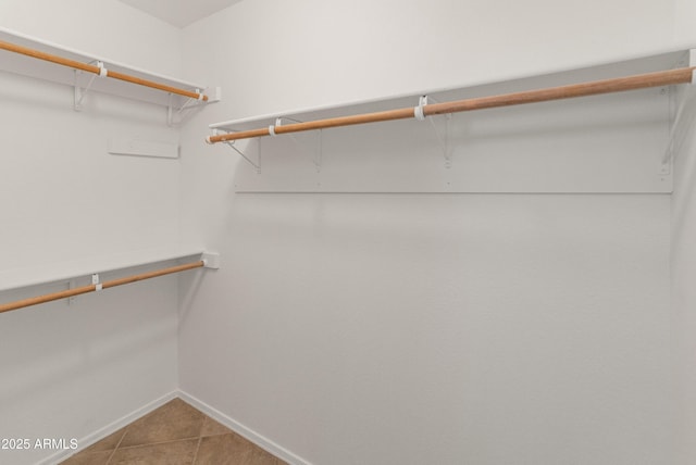 walk in closet with tile patterned flooring