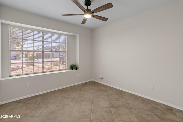 spare room with ceiling fan and baseboards