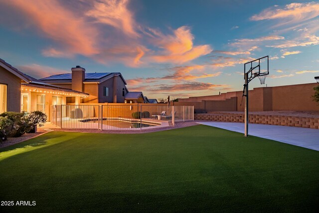 yard at dusk with a patio and a fenced backyard