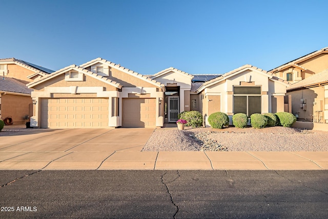 view of front of property with a tiled roof, a garage, stucco siding, and driveway