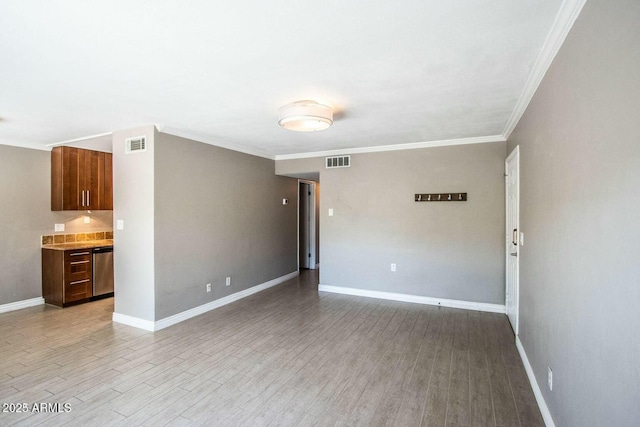 spare room with ornamental molding and light hardwood / wood-style floors