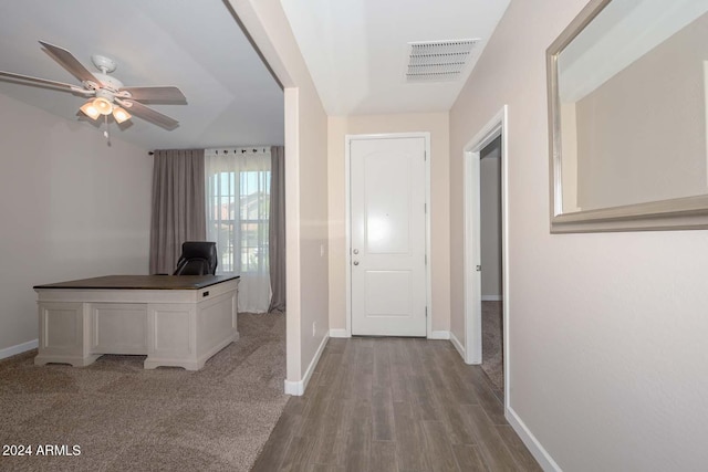 hall with wood finished floors, baseboards, and visible vents