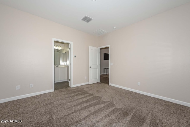 unfurnished bedroom featuring visible vents, carpet floors, baseboards, and ensuite bath