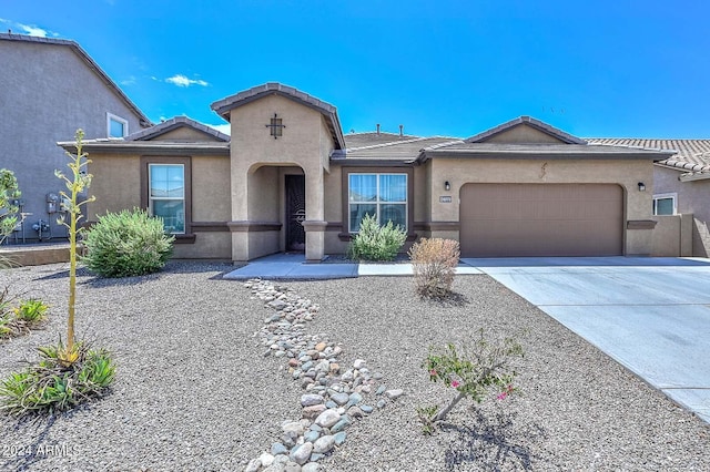 view of front of home with a tile roof, concrete driveway, a garage, and stucco siding