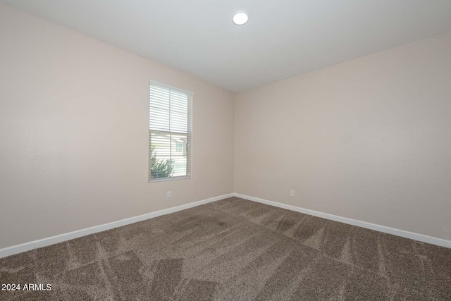 carpeted spare room with baseboards