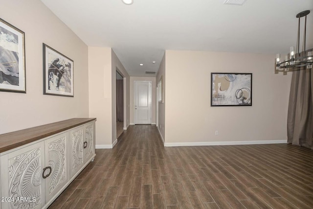 hallway featuring baseboards, visible vents, an inviting chandelier, recessed lighting, and dark wood-style flooring