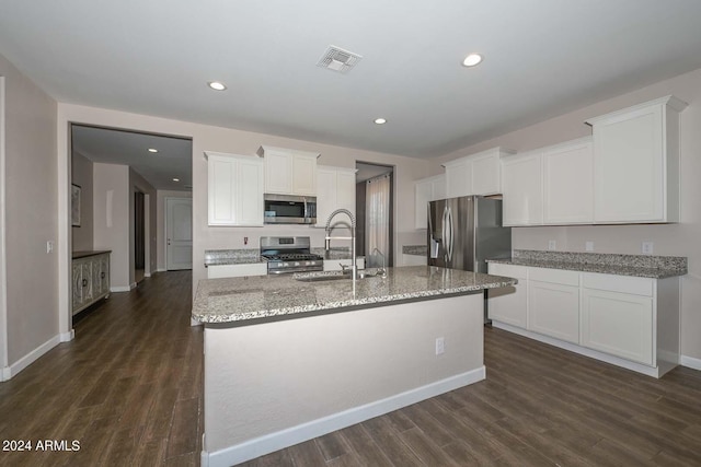 kitchen featuring visible vents, dark wood-type flooring, stainless steel appliances, white cabinetry, and a sink