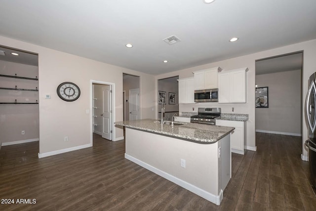 kitchen with light stone counters, visible vents, a sink, stainless steel appliances, and white cabinetry