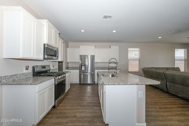 kitchen with visible vents, a sink, open floor plan, dark wood finished floors, and stainless steel appliances