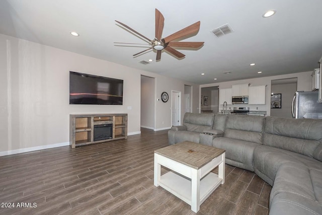 living area featuring visible vents, recessed lighting, a fireplace, and wood finish floors