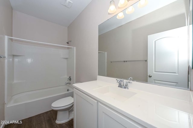 bathroom with visible vents, toilet, wood finished floors, vanity, and  shower combination