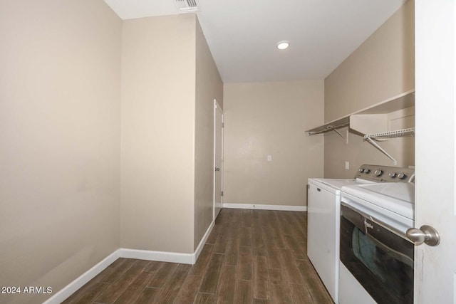 clothes washing area with laundry area, baseboards, dark wood-type flooring, and washer and clothes dryer