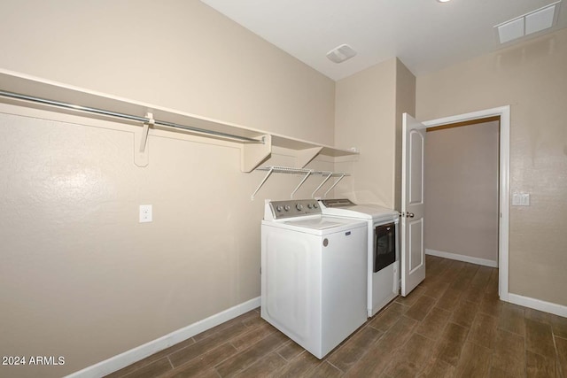 clothes washing area with baseboards, visible vents, wood tiled floor, laundry area, and washer and clothes dryer