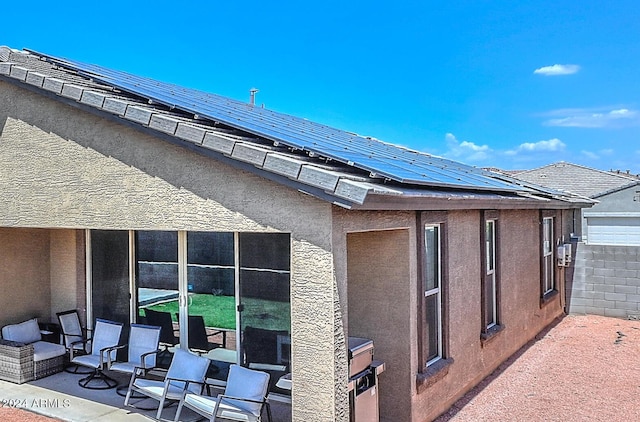 exterior space with roof mounted solar panels and stucco siding