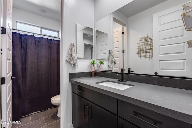 bathroom with vanity, toilet, curtained shower, and tile patterned flooring