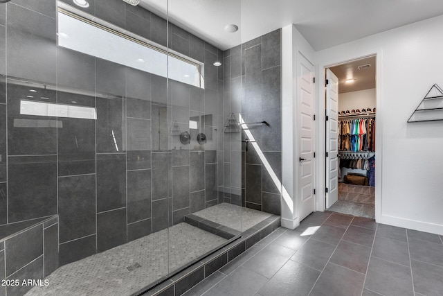 bathroom with tiled shower and tile patterned floors