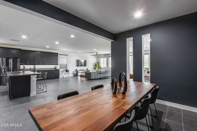 tiled dining room featuring sink and ceiling fan