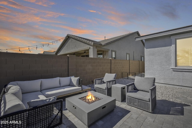 patio terrace at dusk featuring an outdoor living space with a fire pit