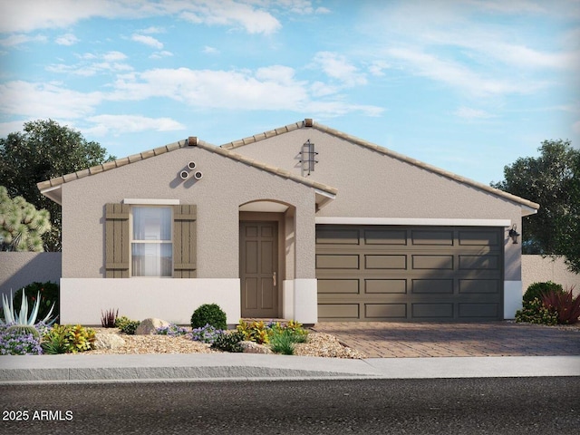 mediterranean / spanish house with decorative driveway, an attached garage, and stucco siding