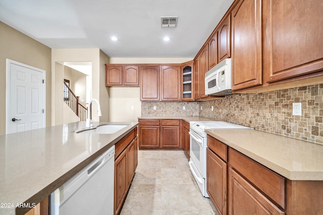 kitchen featuring tasteful backsplash, white appliances, and sink