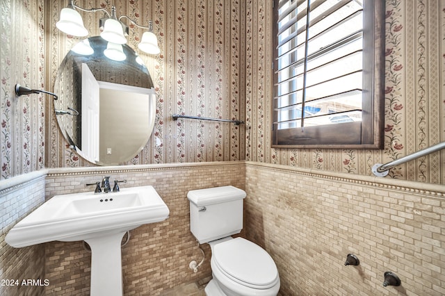 bathroom with sink, tile patterned flooring, toilet, and tile walls