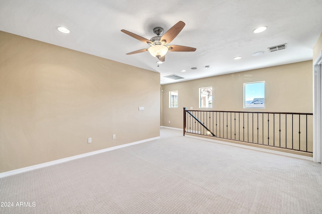 carpeted empty room featuring a wealth of natural light and ceiling fan