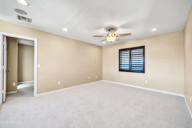 spare room with light colored carpet and ceiling fan