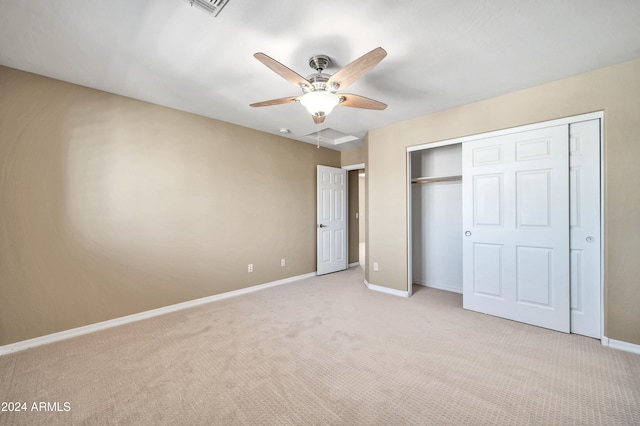 unfurnished bedroom with ceiling fan, light carpet, and a closet