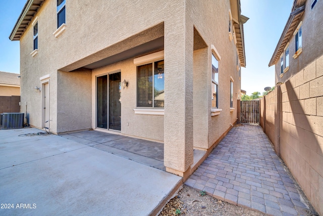 view of side of home with central air condition unit and a patio area