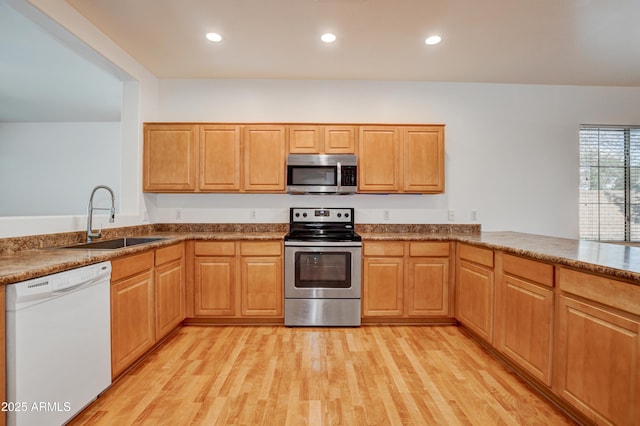 kitchen with recessed lighting, appliances with stainless steel finishes, a sink, and light wood-style floors